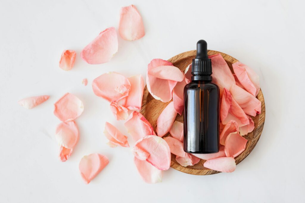 Flacon d’essence florale entouré de pétales colorés, symbole des Fleurs de Bach et de l’équilibre émotionnel naturel qu'elles favorisent