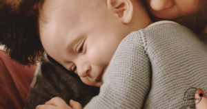 Un bébé dans les bras de ses parents – symbole de lien, de sécurité affective et de libération émotionnelle